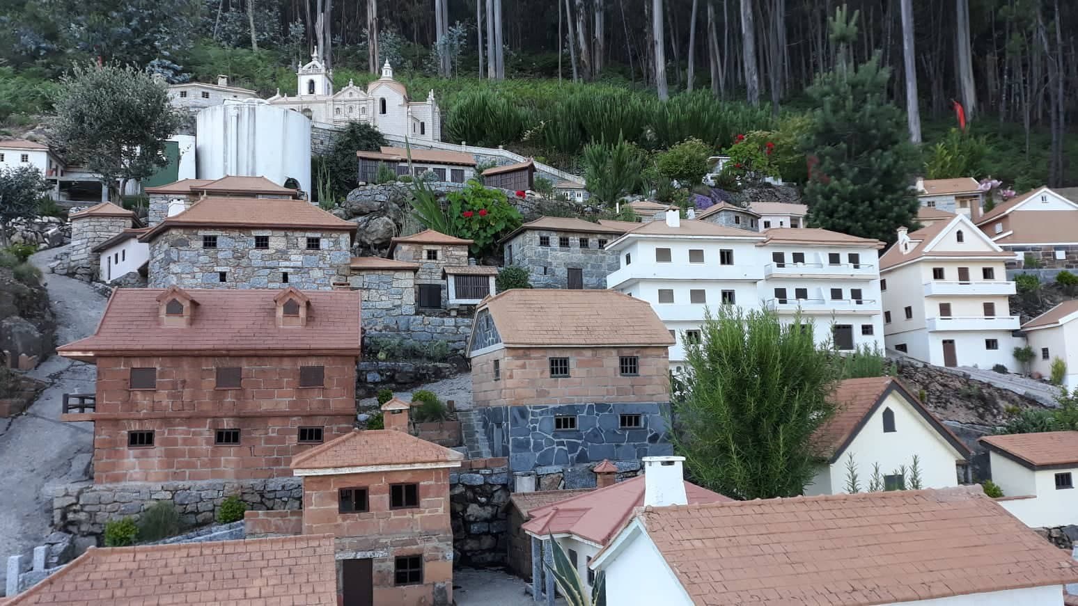 A aldeia em miniatura de Agilde na encosta, com dezenas de casas e o mosteiro ao fundo
